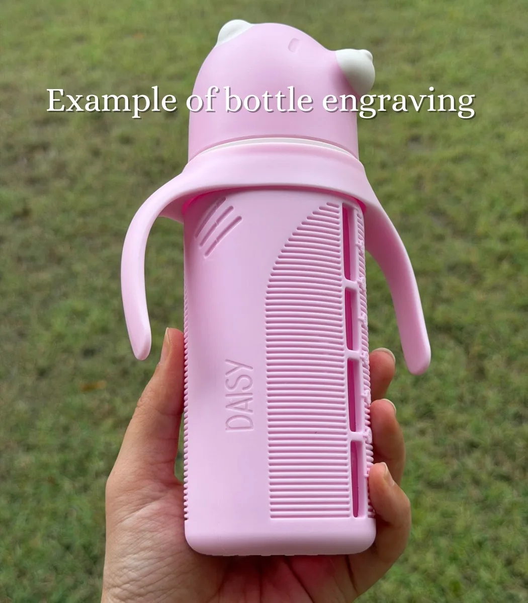 Hand holding a pink KaaKaaBaby bottle outdoors, personalised with the engraved name Daisy